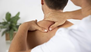 physiotherapist-performing-therapeutic-massage-male-client